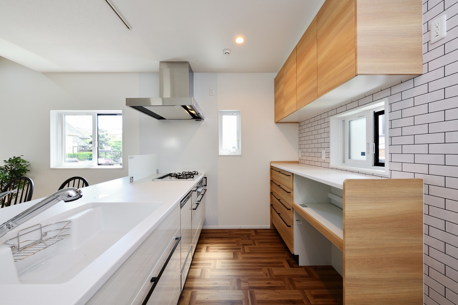 白を基調とした空間に、木目やタイルといったアクセントが光るキッチン
